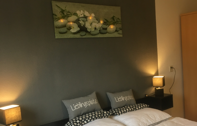 Foto Schlafzimmer mit Doppelbett, Nachtischleuchten und Bild darüber