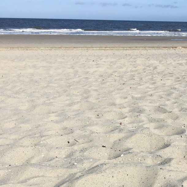 Foto Strand und im Hintergrund die Wellen des Meeres