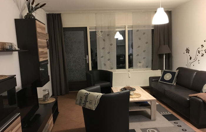 Foto Wohnzimmer Beach Appartement 4 mit Sofa, Sessel, Couchtisch und Schränken