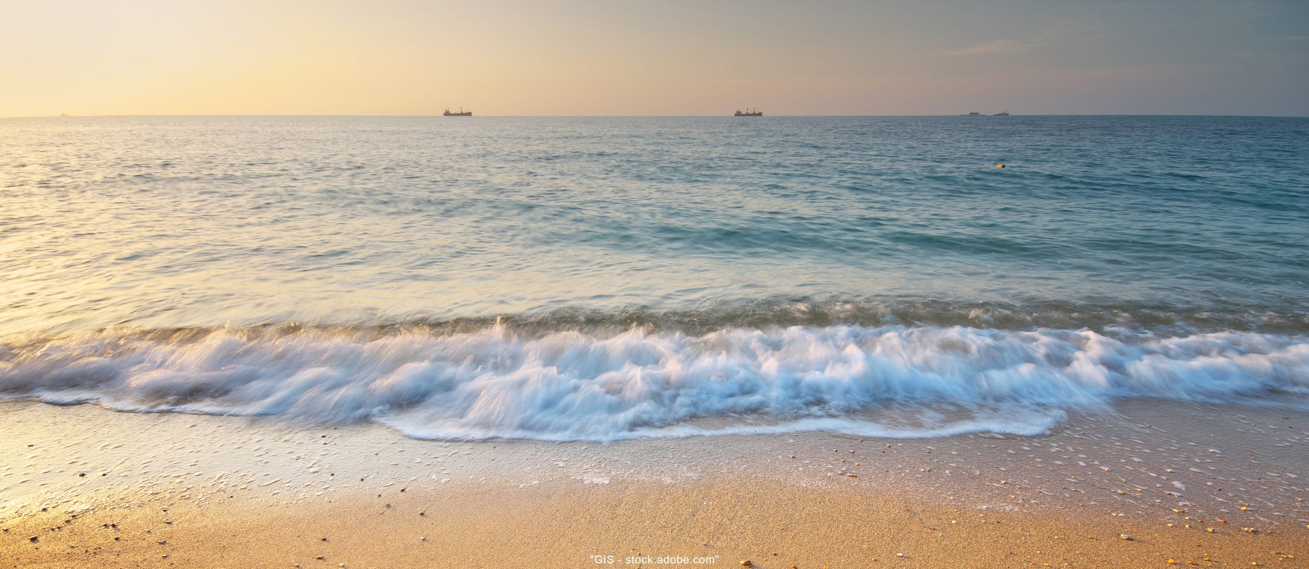 Foto vorne unten Strand mit Wellen darüber Meer im Sonnenuntergang