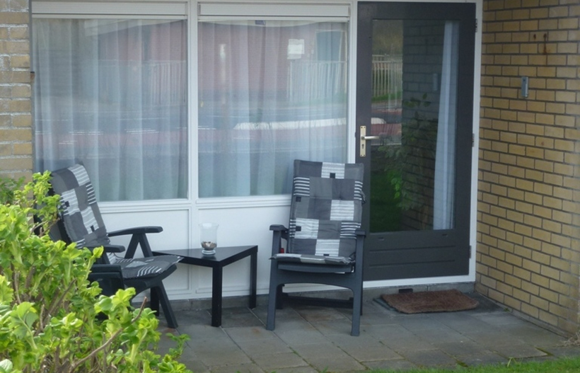 Foto Terrasse des Beach Appartement 3 mit Tisch und zwei Stühlen vor dem Fenter und der Terrassentür der Ferienwohnung